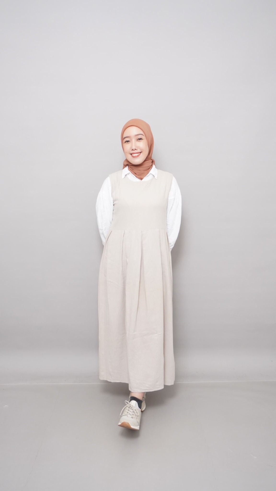 Potret Rizka Mifta mengenakan hijab terracotta dan busana ivory